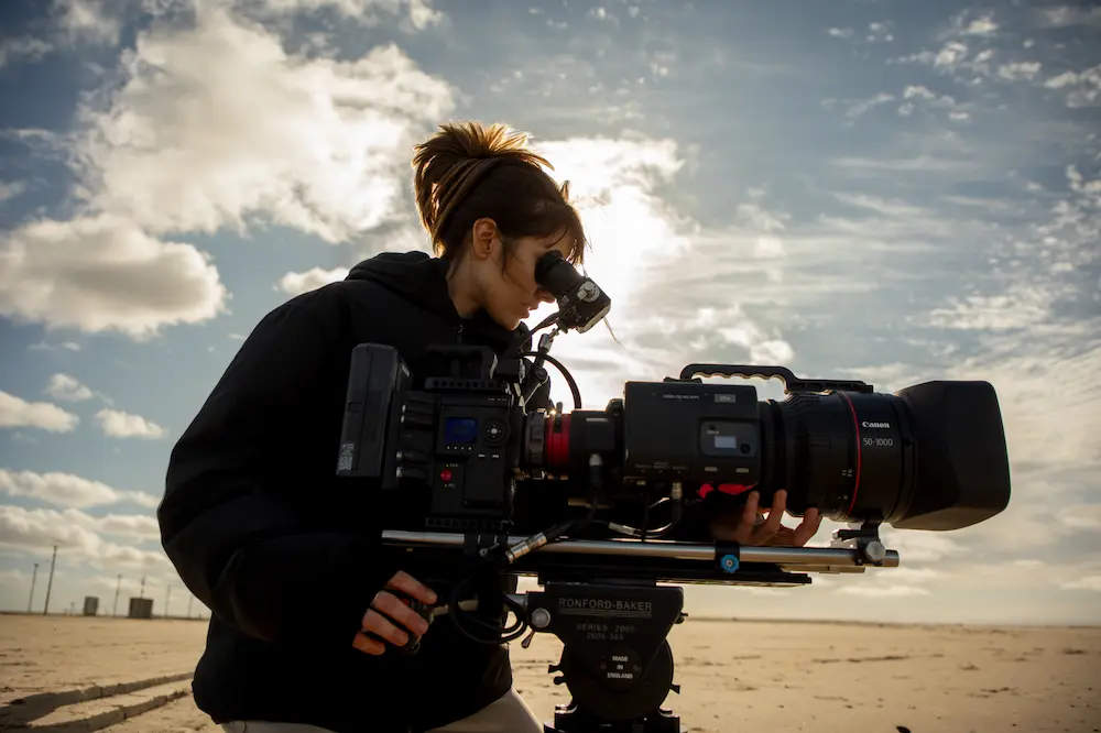 agua-invadida-sosa-documentalista | Ambienta - Staging Carolina Sosa filmando con una cámara profesional en la costa, reforzando su rol como directora de Agua Invadida.