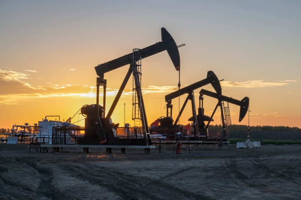 Three oil well pumpjacks at sunrise near Crossfield, Alberta, Canada | Ambienta