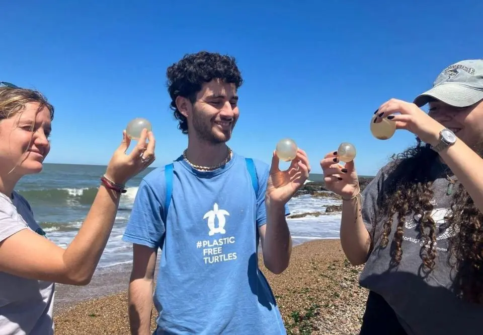 Martín Laspiur junto a jóvenes voluntarios de la organización Karumbé en la costa uruguaya.