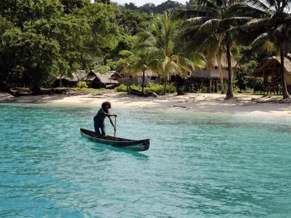 Persona navegando en canoa cerca de la costa, impacto del cambio climático en el Pacífico.