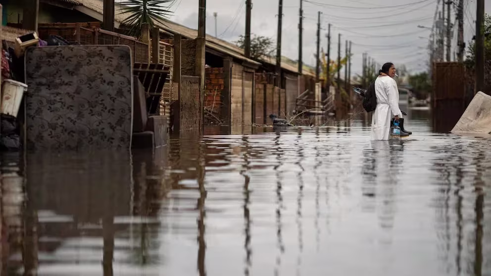 América Latina En La zona Roja Del Clima 8 Países Vulnerables Sin Fondos Para Adaptarse Mujer caminando por una calle inundada tras un desastre climático en Brasil.