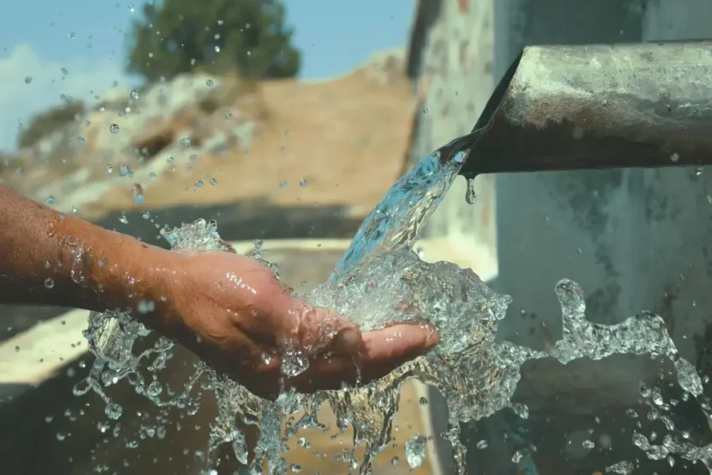 fuente-de-agua | Ambienta Mano sumergida en agua clara, simbolizando la conexión humana y la gestión consciente del recurso hídrico.