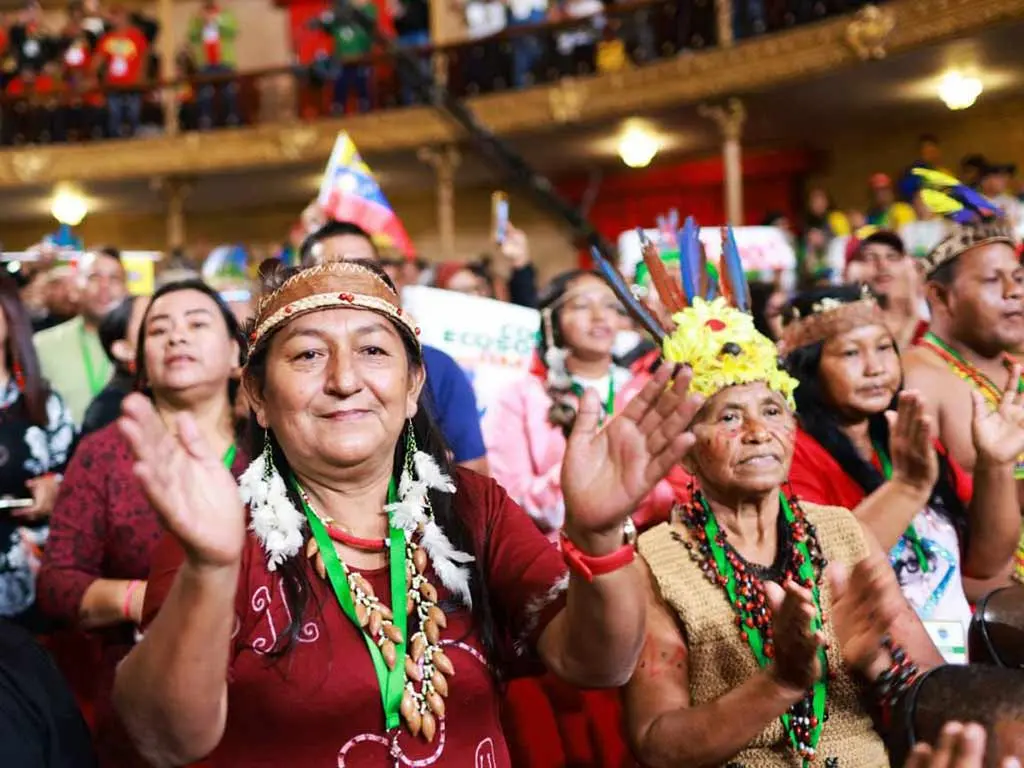 Plenario del Congreso Mundial en Defensa de la Madre Tierra con delegados indígenas aplaudiendo en Caracas.
