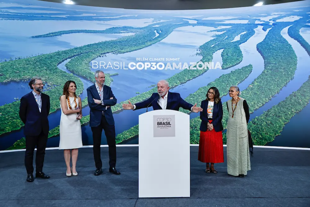 Lula en la COP30 en Belém, frente a imagen aérea de la Amazonia
