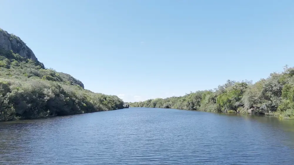 Río Santa Lucía en el Geoparque Manantiales Serranos, rodeado de vegetación nativa y laderas rocosas en Lavalleja