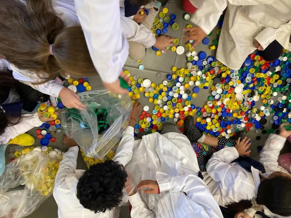 Niños de una escuela pública en Uruguay clasificando tapitas de plástico por colores como parte del programa educativo de Circula.