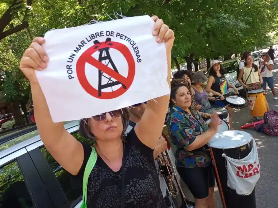 Manifestante del colectivo Mar Libre de Petroleras sostiene una pancarta contra la prospección petrolera en Uruguay durante una movilización.