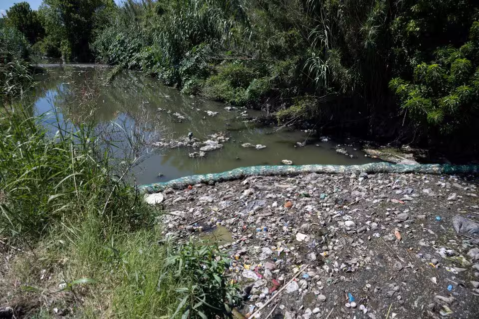 Acumulación de basura y plásticos en un curso de agua de los Bañados de Carrasco.