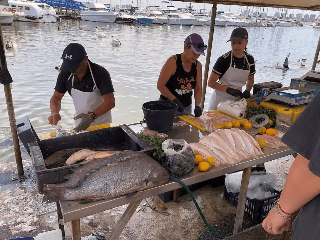 Pescadores preparando pescado fresco en el puerto de Punta del Este.