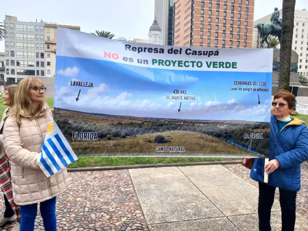 Manifestantes del colectivo Vecinos del Casupá sostienen pancarta en la Plaza Independencia durante la protesta por Casupá.